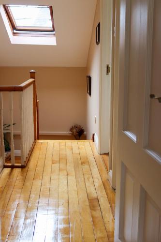 an empty room with a skylight and a wooden floor at Ashe Street in Clonakilty