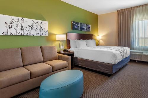 CrosbyにあるSleep Inn & Suitesのベッドとソファ付きのホテルルーム