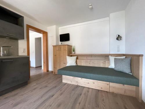a living room with a green couch in a kitchen at Hotel & Suites Glück Auf in Mayrhofen