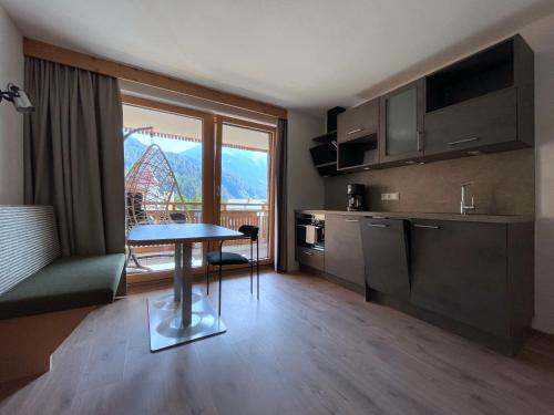 a kitchen with a table and a view of a roller coaster at Hotel & Suites Glück Auf in Mayrhofen