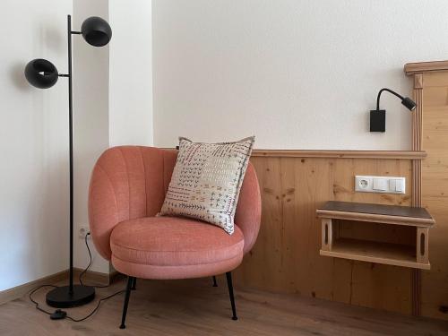 a pink chair with a pillow in a room at Hotel & Suites Glück Auf in Mayrhofen
