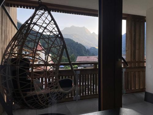 a hammock on a balcony with a view of a mountain at Hotel & Suites Glück Auf in Mayrhofen