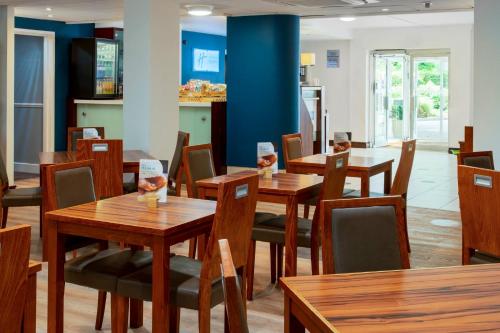 a dining room with wooden tables and chairs at Holiday Inn Express York by IHG in York