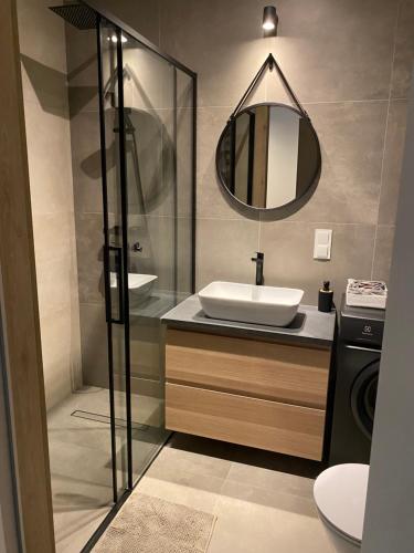 een badkamer met een wastafel en een spiegel bij Apartamenty Poproszę Nad Morze in Jastrzębia Góra