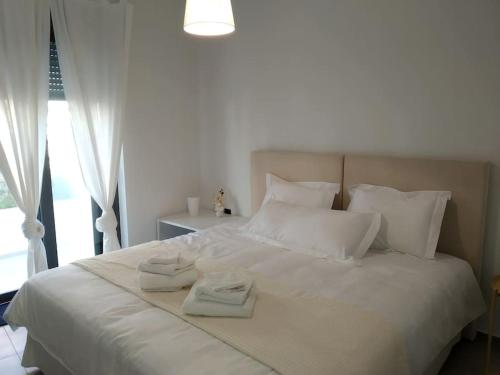 a bedroom with a white bed with towels on it at Casa Lagada Kos Private Residence. in (( Kermetés ))