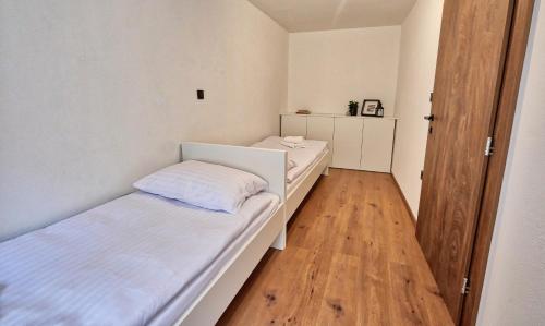 a room with two beds and a wooden floor at AUžlak hiša, apartments. in Luče