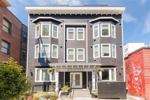 a gray house with white trim on a street at Sonder The Boylston in Seattle