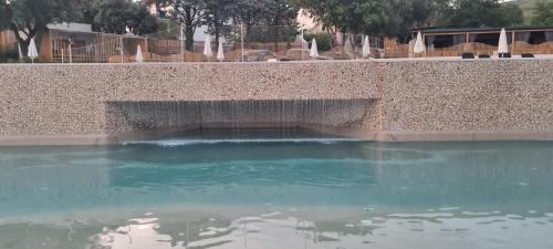 a pool of water next to a retaining wall at Mobile home KMZ in Selce