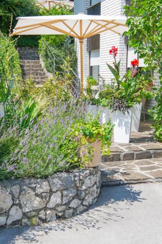 a garden with flowers and a stone wall at Apartment Karlie in Rogaška Slatina