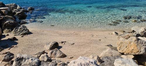 a beach with rocks and the clear blue water at Mobile home KMZ in Selce