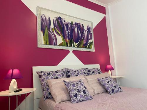 バーリにあるAlloggio breve Antheaの紫の壁のベッドルーム1室、紫の枕付きのベッド1台が備わります。