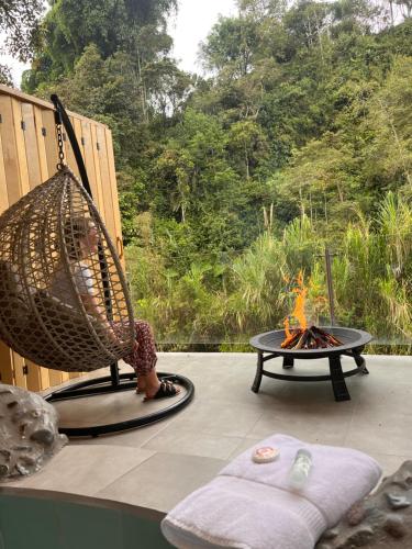 a hammock sitting on a patio with a fire pit at Saguamby Mindo Lodge in Mindo