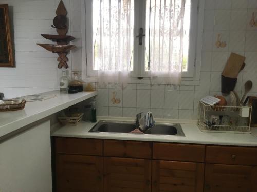 a kitchen counter with a sink and a window at Vintage Beach House in Alexandroupoli