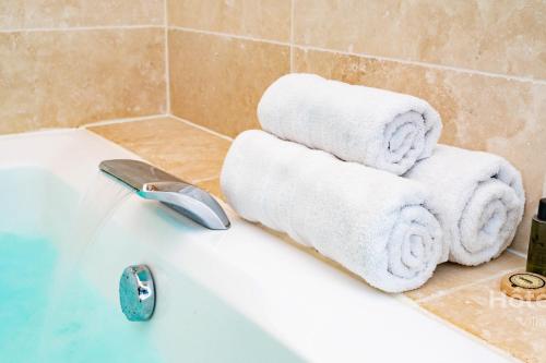 d'une baignoire blanche avec des serviettes. dans l'établissement La Vedrenne Grange connectée à Limoges, à Bonnac-la-Côte