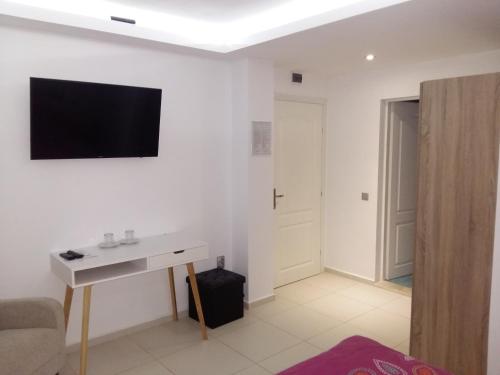 a living room with a tv on a white wall at Guest House Harmony in Veliko Tŭrnovo