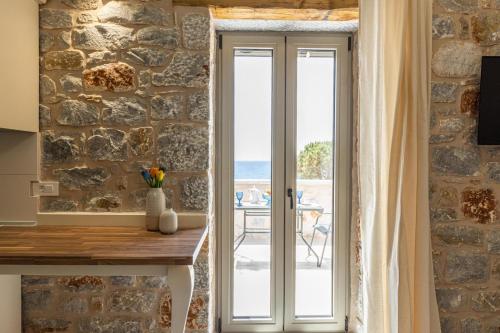 a door leading to a patio with a view of the ocean at Elaianthos 2 in Gythio
