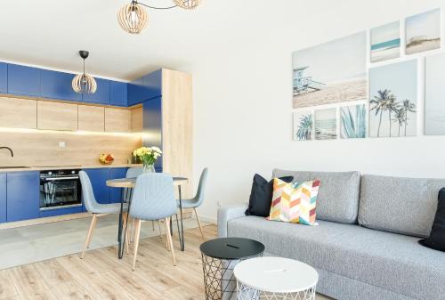 a living room with a couch and a table at Navy Blue Dream - SPA - Basen - Parking in Dziwnów