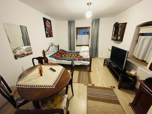 a living room with a table and a couch at Casa bunicilor in Nădăştia de Sus