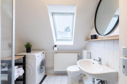 ein Badezimmer mit Waschmaschine und Waschbecken in der Unterkunft Tante Tine in Husum