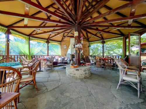 een grote kamer met tafels en stoelen en een open haard bij Patra Rooms Skala Prinou in Prinos