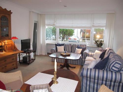 - un salon avec deux canapés et une table dans l'établissement Appartement Deckerstraße 19-21 Appartement 10, à Westerland