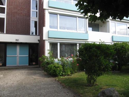 un immeuble avec des portes bleues et des fleurs dans la cour dans l'établissement Appartement Deckerstraße 19-21 Appartement 10, à Westerland