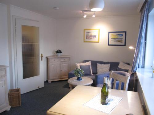 - un salon avec un canapé bleu et une table dans l'établissement Appartement Andreas-Dirk-Str 1 Appartement 103, à Westerland