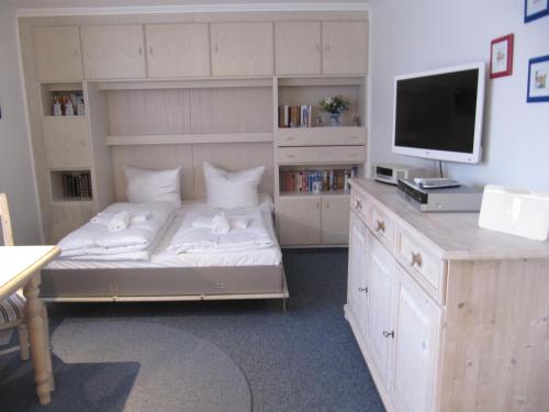 - une chambre avec un lit et un bureau avec une télévision dans l'établissement Appartement Andreas-Dirk-Str 1 Appartement 103, à Westerland