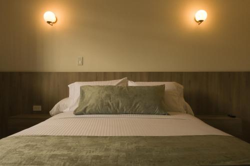 a bedroom with a bed with two lights on the wall at El Zócalo Hotel Boutique in Filandia