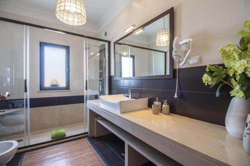 a bathroom with a sink and a mirror at Villa Maya by Algarve Holidays in Almancil