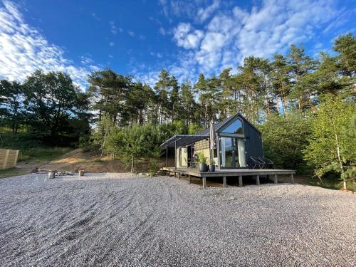 a tiny house on the beach with a gravel driveway at Domki na Kaszubach - Gołubie - Sikorska Dolina II in Sikorzyno