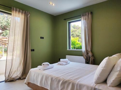 a bedroom with a bed with white sheets and a window at Billie's Holiday in Preveza
