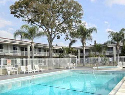 a swimming pool with chairs and a building at Quality Inn Saint Petersburg North-Tampa Bay in St. Petersburg