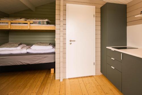 a room with two bunk beds and a kitchen at Móar Cottage in Akranes