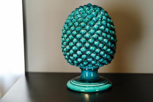 a green pineapple on a green vase on a table at Aquasuite - Luxury Experience & Spa in Palermo