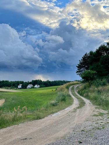 a dirt road in the middle of a field at Domki na Kaszubach z banią jacuzzi - Gołubie - Sikorska Dolina III in Stara Sikorska Huta