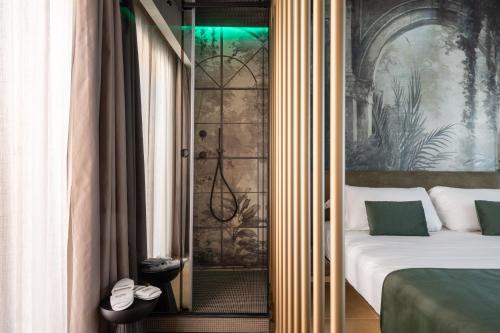 a bedroom with a bed and a glass door to a shower at Aquasuite - Luxury Experience & Spa in Palermo
