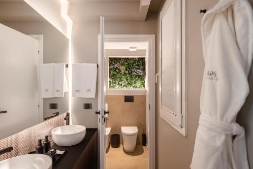 a bathroom with a sink and a toilet and a window at Aquasuite - Luxury Experience & Spa in Palermo