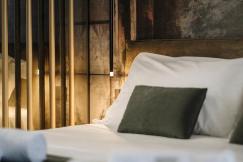 a bed with a green pillow on top of it at Aquasuite - Luxury Experience & Spa in Palermo