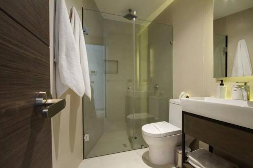 ein Badezimmer mit Dusche, Toilette und Waschbecken in der Unterkunft Beautiful Penthouse with Private Pool Amazing Views in Tulum