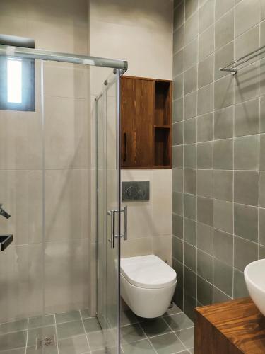 a bathroom with a toilet and a glass shower at Billie's Holiday in Preveza