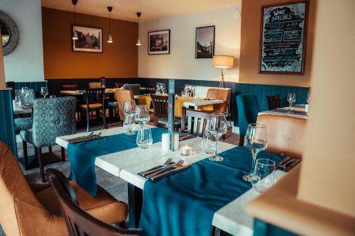 a dining room with tables and chairs with wine glasses at The Bull Inn in Woolpit