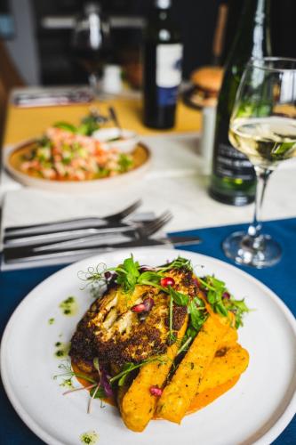 a plate of food on a table with a glass of wine at The Bull Inn in Woolpit