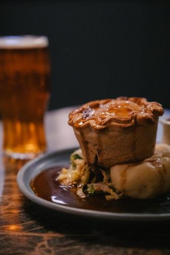 a piece of cake on a plate next to a glass of beer at The Bull Inn in Woolpit