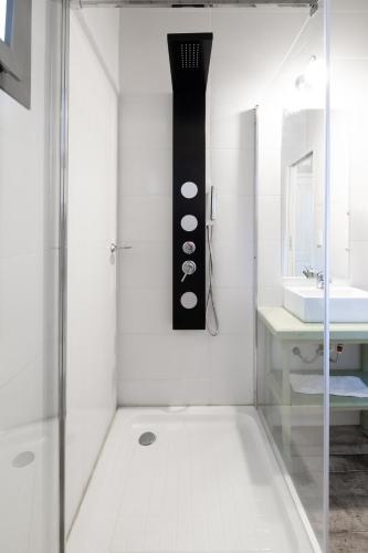 a white bathroom with a shower and a sink at Atelier Hotel Charme & Spa in Villa General Belgrano