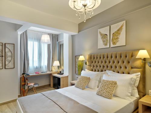 ein Schlafzimmer mit einem großen Bett und einem Kronleuchter in der Unterkunft Acropolis City Life BH in Athen
