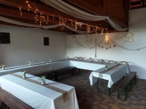 a dining room with two tables and chairs and lights at Vár-Liget Vendégház in Kisnána