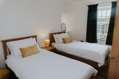 2 Betten in einem Zimmer mit Fenster in der Unterkunft Fisherman's Cottage in Vatsker