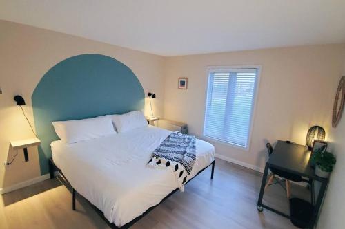 a bedroom with a large white bed and a window at Burke Abode - Trailside Condo with King & Full Beds in East Burke