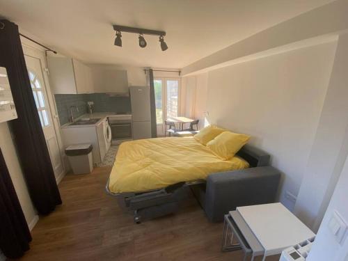 een slaapkamer met een bed en een bank en een keuken bij Une pause en Ile de France - 450 M RER E in Villiers-sur-Marne